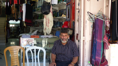 Abu Muhammad sentado en la puerta de su comercio  - Leire Regadas Julio 2019