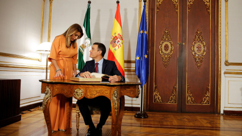 El presidente del Gobierno, Pedro Sánchez, firma en el libro de visitas del Palacio de San Telmo, sede de la Presidencia de la Junta de Andalucía en Sevilla, en presencia de Susana Díaz. REUTERS/Marcelo del Pozo