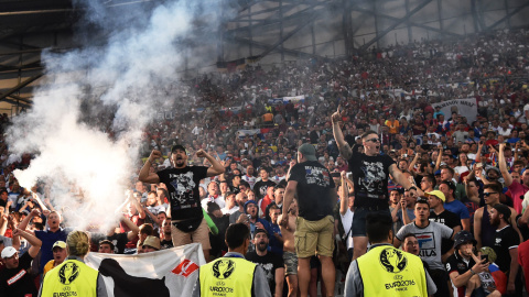 Radicales cantan y encienden una bengala en las gradas del estadio Vélodrome ante agentes de seguridad. /AFP