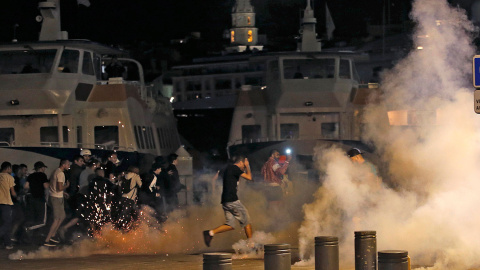 Ultras en el puerto de Marsella lanzando bengalas y botes de humo anoche tras el Inglaterra-Rusia. /REUTERS