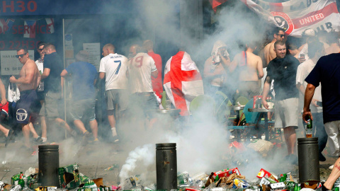 Hinchas ingleses se apartan tras lanzar un petardo en una calle llena de desperdicios y botellas de cerveza vacías. /REUTERS