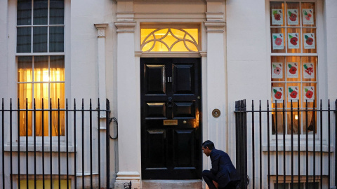 Fotografía de noviembre de 2020 de Rishi Sunak, entonces ministro de Finanzas británico, coloca unas velas en la puerta de la sede de su departamento, en el número 11 de Downing Street, con motivo de la festividad hindú de Diwali. REUTERS/J