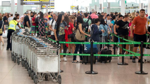 Pasajeros en tránsito durante la tercera jornada de huelga de este domingo en El Prat. / EFE