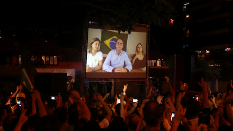 Seguidores de Bolsonaro siguen su discurso por una pantalla tras ganar las elecciones en Brasil. /REUTERS