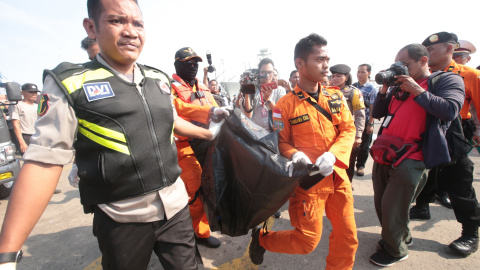 Miembros de los servicios de rescate trasladan los cuerpos de las víctimas del avión accidentado. EFE/ Bagus Indahono