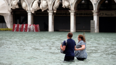 Una pareja intenta hacerse hueco en la inundada plaza de San Marcos. REUTERS/Manuel Silvestri