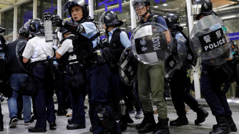 La policía antidisturbios usa spray de pimienta para dispersar a los manifestantes contra el proyecto de ley de extradición durante una manifestación masiva después de que una mujer recibió un disparo en el ojo, en el aeropuerto internacion