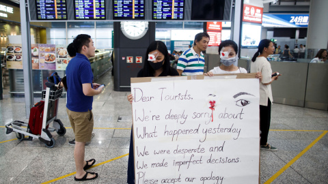 Manifestantes se disculpan con los turistas por los enfrentamientos con la policía en el aeropuerto. / Reuters