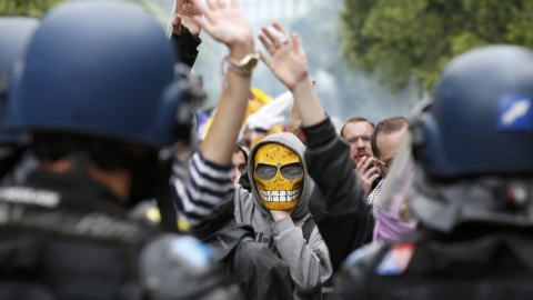 Un joven enmascarado reacciona frente a los gendarmes franceses durante una manifestación en París contra la reforma laboral del Gobierno de Hollande. REUTERS/Philippe Wojazer