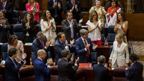 La candidata del PP a la Presidencia de la Comunidad de Madrid, Cristina Cifuentes (d), es aplaudida por los diputados de la Asamblea de Madrid tras ser elegida nueva presidenta de la Comunidad durante la segunda jornada del debate de inves