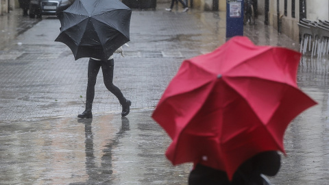 Dos personas sostienen paraguas como consecuencia de la lluvia, a 6 de febrero de 2023, en Valencia, Comunidad Valenciana (España).