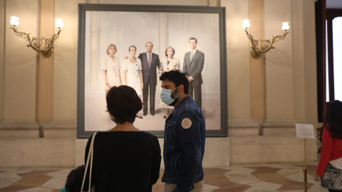 10/06/2020-Un visitante protegido con mascarilla pasea junto al cuadro del pintor Antonio López 'La familia de Juan Carlos I' en el interior del Palacio Real  el 10 de junio de 2020.