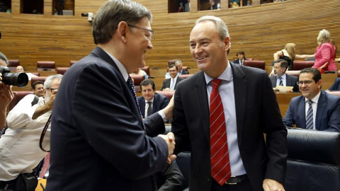 El candidato a la presidencia de la Generalitat, Ximo Puig (d), saluda al presidente de la Generalitat en funciones, Alberto Fabra (d), a su llegada al pleno de Les Corts Valencianes para su investidura