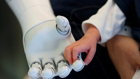 El robot humanoide Pepper, diseñado para dar la bienvenida y cuidar de visitantes y pacientes, sujeta la mano de un recién nacido en el hospital AZ Damiaan en Ostend, Bélgica. REUTERS/Francois Lenoir