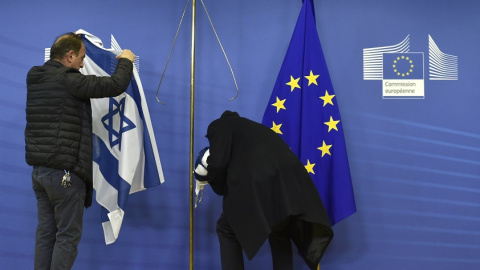 Empleados de la Comisión Europea retiran la bandera israelí en Bruselas, en una imagen de archivo. / AFP - JOHN THYS