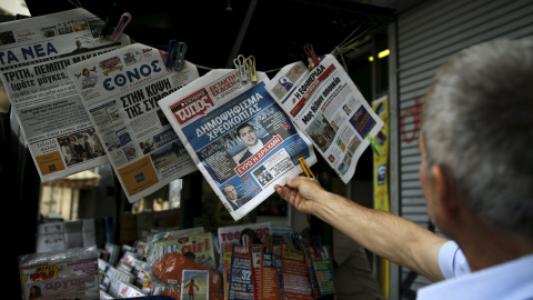 Un hombre lee en un quiosco en Atenas los periodicos del día con la noticia de la convocatoria del referendum sobre el rescate.  REUTERS/Alkis Konstantinidis