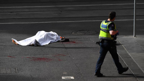 09/11/2018.- El cadáver de una víctima yace sobre el asfalto después de que un hombre armado con un cuchillo atacase a varias personas en la calle Bourke de Melbourne (Australia), hoy, 9 de noviembre de 2018. Una persona murió y otras dos s