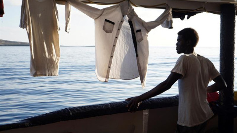 Un migrante mira este domingo desde la cubierta de el buque Open Arms las costas de Lampedusa (Italia). - EFE