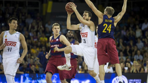 El base del Real Madrid Sergio Rodriguez  intenta un lanzamiento ante la oposición de el escolta del FC Barcelona Lassa Brad Oleson  durante el segundo partido de la final por el título de la Liga ACB que se juega hoy en el Palau Blaugrana.