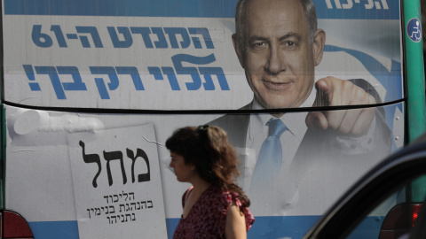 Una mujer pasa junto a una valla publicitaria del ex primer ministro israelí y líder del partido Likud, Benjamin Netanyahu, en Jerusalén, Israel.