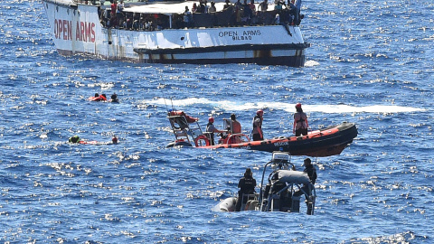 Varios migrantes saltan por la borda del Open Arms para llegar a nado a la isla italiana de Lapedusa, desesperados tas 19 días encerrados en el barco español.- REUTERS