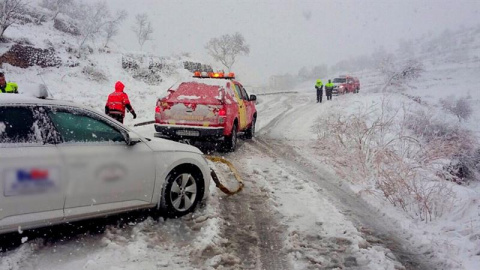 Los bomberos trasladan a un coche durante una nevada. EFE