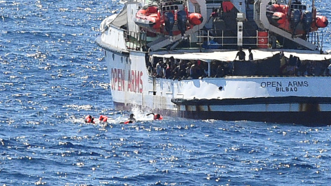 Varios migrantes saltan por la borda del Open Arms para llegar a nado a la isla italiana de Lapedusa, desesperados tas 19 días encerrados en el barco español.- REUTERS