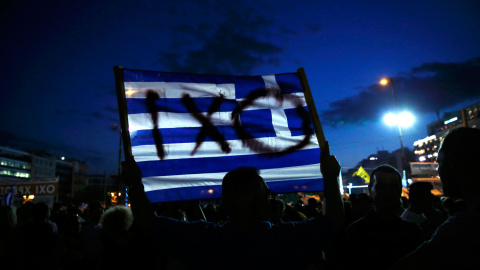 Un manifestante sostiene una bandera griega durante una manifestación contra la austeridad en Atenas, Grecia.- REUTERS / Alkis Konstantinidis