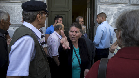 Una mujer se queja en la puerta de un banco griego cerrado mientras espera su apertura para poder cobrar su pensión tras declararse el corralito o control de capitales en el país.- REUTERS / Marko Djurica