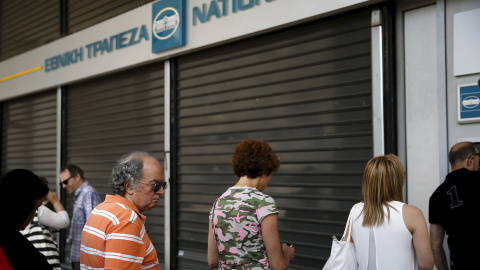 La gente hace cola en un cajero automático  del Banco Nacional en Atenas. Tras el anuncio del referéndum para aceptar o no las medidas exigidas por los acreedores, las sucursales han cerrado y el BCE ha dejado de inyectar liquidez a los ban