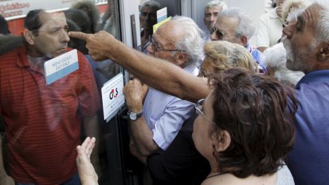 Pensionistas esperando en la puerta del Banco Nacional de Grecia para cobrar su pensión en Heraklion, en la isla de Creta, el día después de que se declarara el control de capitales, conocido como corralito. Los bancos sólo han abierto para