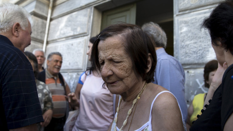 Varios jubilados se agolpan en una sucursal cerrada de Banco Nacional en Atenas. Tras el control de capitales establecido y el cierre de bancos, el Gobierno ha anunciado que abrirán para que los pensionitas puedan cobrar sus pensiones.- REU