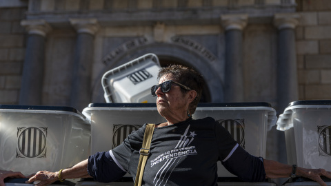 Varias personas se manifiestan junto a unas urnas de votar colocadas en un acto simbólico de la ANC, en Plaza Sant Jaume, a 1 de octubre de 2022, en Barcelona.