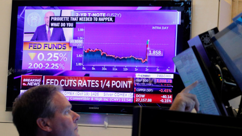 Un operador de la Bolsa de Nueva York (NYSE, en sus siglas en inglés) observa en un monitor el anuncio de la última bajada de tipos de la Reserva Federal de EEUU. REUTERS / Brendan McDermid