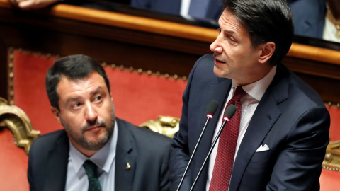 El ya exprimer ministro de Italia, Giuseppe Conte, habla con el ministro de Interior, Matteo Salvini, este martes en el parlamento italiano. REUTERS