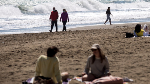 Varias personas pasean este domingo por la playa de La Misericordia aprovechando el buen tiempo