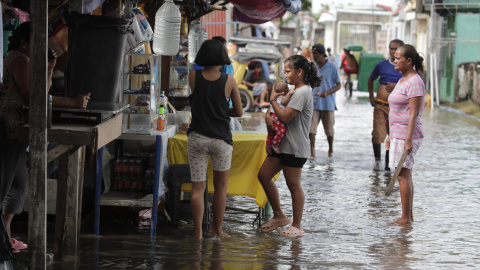 Varias personas visitan un cementerio inundado en Kawit (Filipinas), a 31 de octubre de 2022.