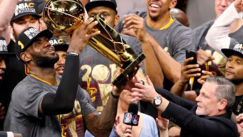 La estrella de los Cavaliers, LeBron James, levanta el trofeo de campeones de la NBA. EFE/JOHN G. MABANGLO