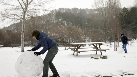 Un niño juega con la nieve en un área recreativa próxima a la localidad de Robledondo, en la sierra norte de Madrid. / BALLESTEROS (EFE)