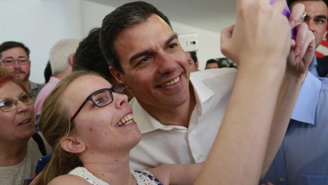 El secretario general del PSOE, Pedro Sánchez, se hace una fotografía con una simpatizante durante el acto electoral con las Juventudes Socialistas, en el Centro Cultural Tomás y Valiente, en la localidad madrileña de Fuenlabrada./ EFE