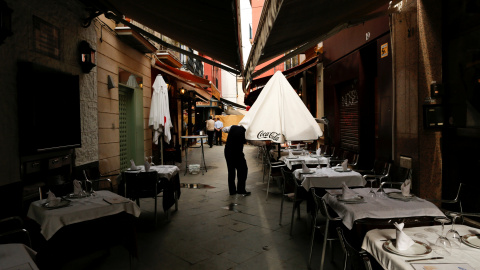 Un camarero despliega una sombrilla de la terraza de un bar en Sevilla. REUTERS/Marcelo del Pozo