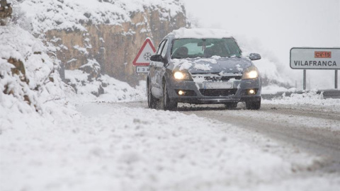 Un coche circula por la CV15 en el Coll d'Ares cuando la nieve ha cubierto el interior de la provincia de Castellón. /EFE