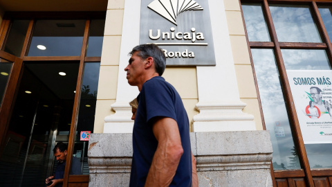 Un hombre pasa por delante de unas oficinas de Unicaja en Ronda (Málaga). REUTERS/Jon Nazca