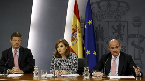 La vicepresidenta del Gobierno Soraya Sáenz de Santamaría junto a los ministros de Justicia, Rafael Catalá, (iz),y Economía, Luis de Guindos. /EFE