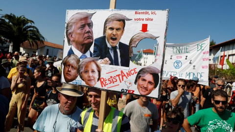 Los manifestantes sostienen una pancarta durante una manifestación de la Contracumbre del G7