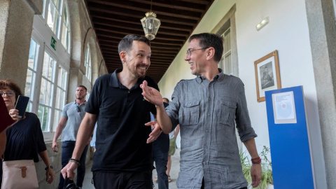 El exvicepresidente del Gobierno de España, Pablo Iglesias y el cofundador de Podemos, Juan Carlos Monedero, conversan a su llegada a una mesa redonda en San Lorenzo de El Escorial, a 18 de julio de 2022.