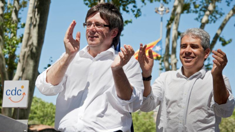 El cabeza de lista de CDC, Francesc Homs (d), y el presidente de la Generalitat, Carles Puigdemont (i), saludan a los asistentes tras la comida celebrada con motivo del acto de final de campaña de CDC en Girona celebrado en el Parc de la De