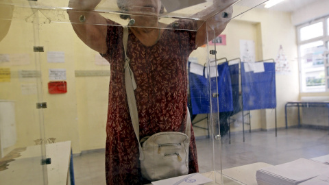 Una mujer deposita su voto en las primeras horas de votación en Grecia. REUTERS/Jean-Paul Pelissier