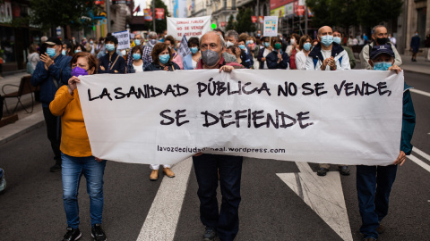 Varias personas con una pancarta en la que se lee: `La sanidad pública no se vende, se defiende´, participan en la manifestación convocada por Marea Blanca, en defensa de la Atención Primaria de la Comunidad de Madrid, a 20 de junio de 2021