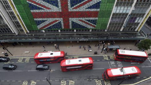 Peatones caminan por Oxford Street donde se colocó una bandera británica en la fachada de unos grandes almacenes en Londres durante la jornada de referéndum por el Brexit. EFE